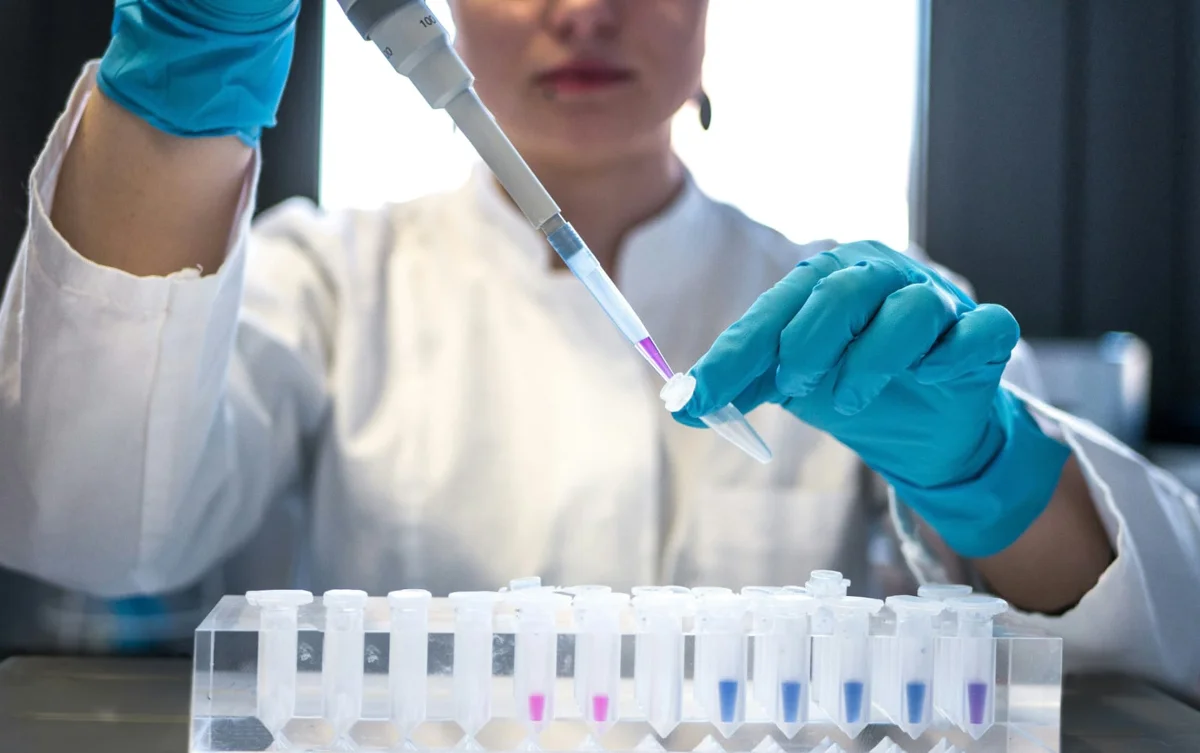 Laboratory scientist pipetting samples into vials
